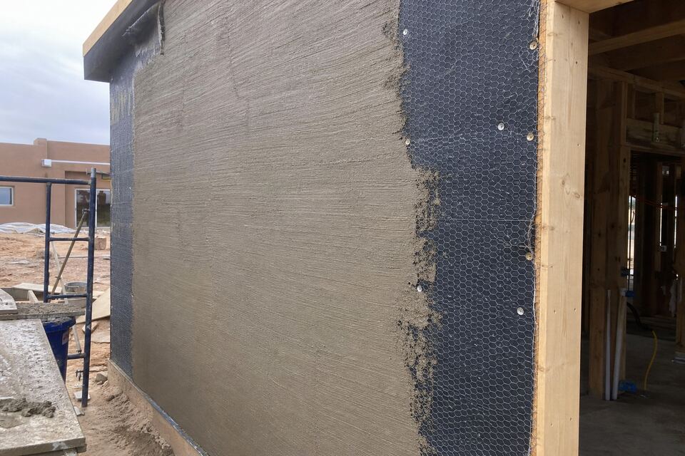 Brown coat being floated on a new stucco wall over lath in New Mexico